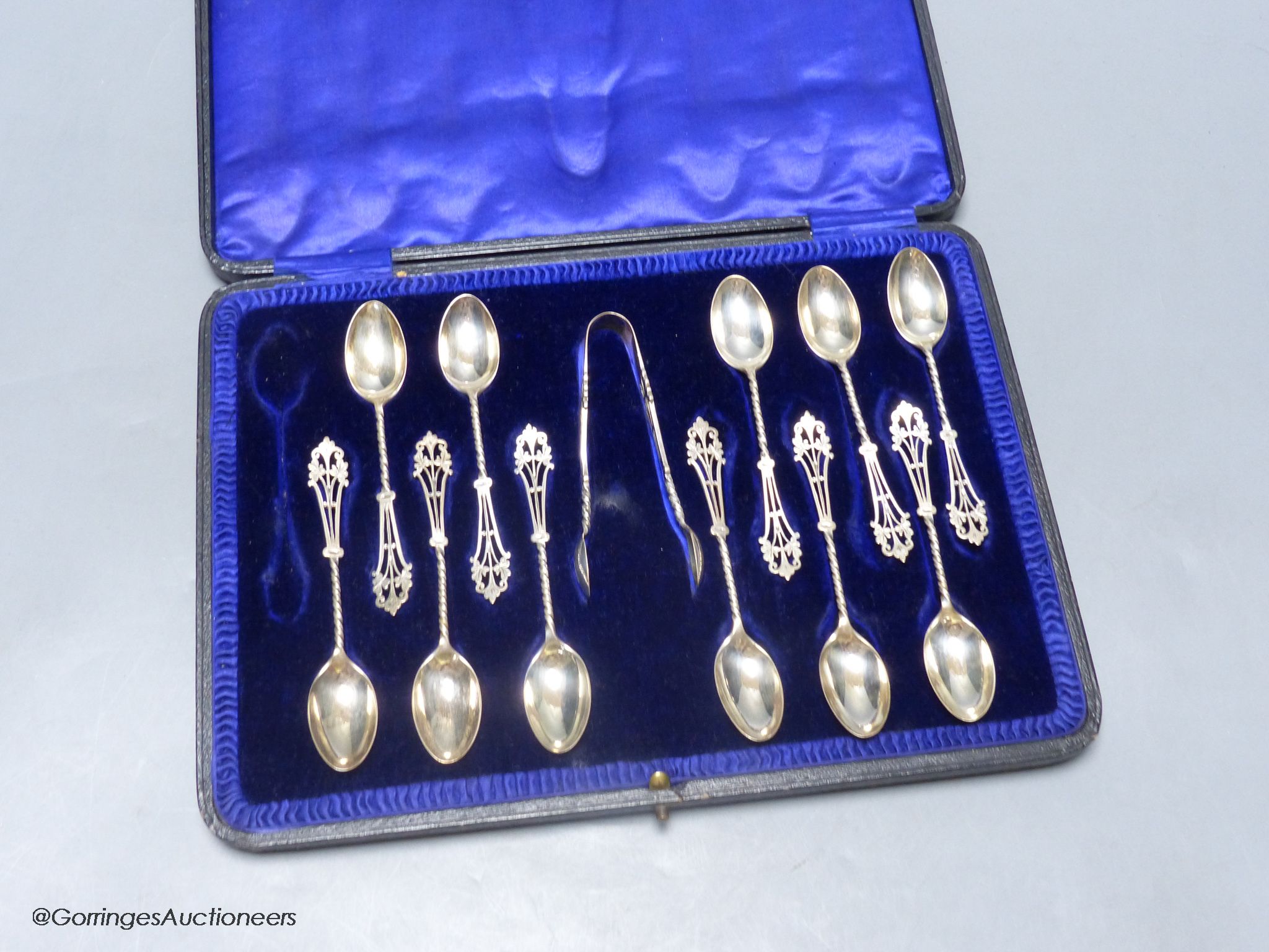 A cased set of eleven (ex 12) pierced silver teaspoons and pair of sugar tongs, John Round & Son Ltd, Sheffield, 1912